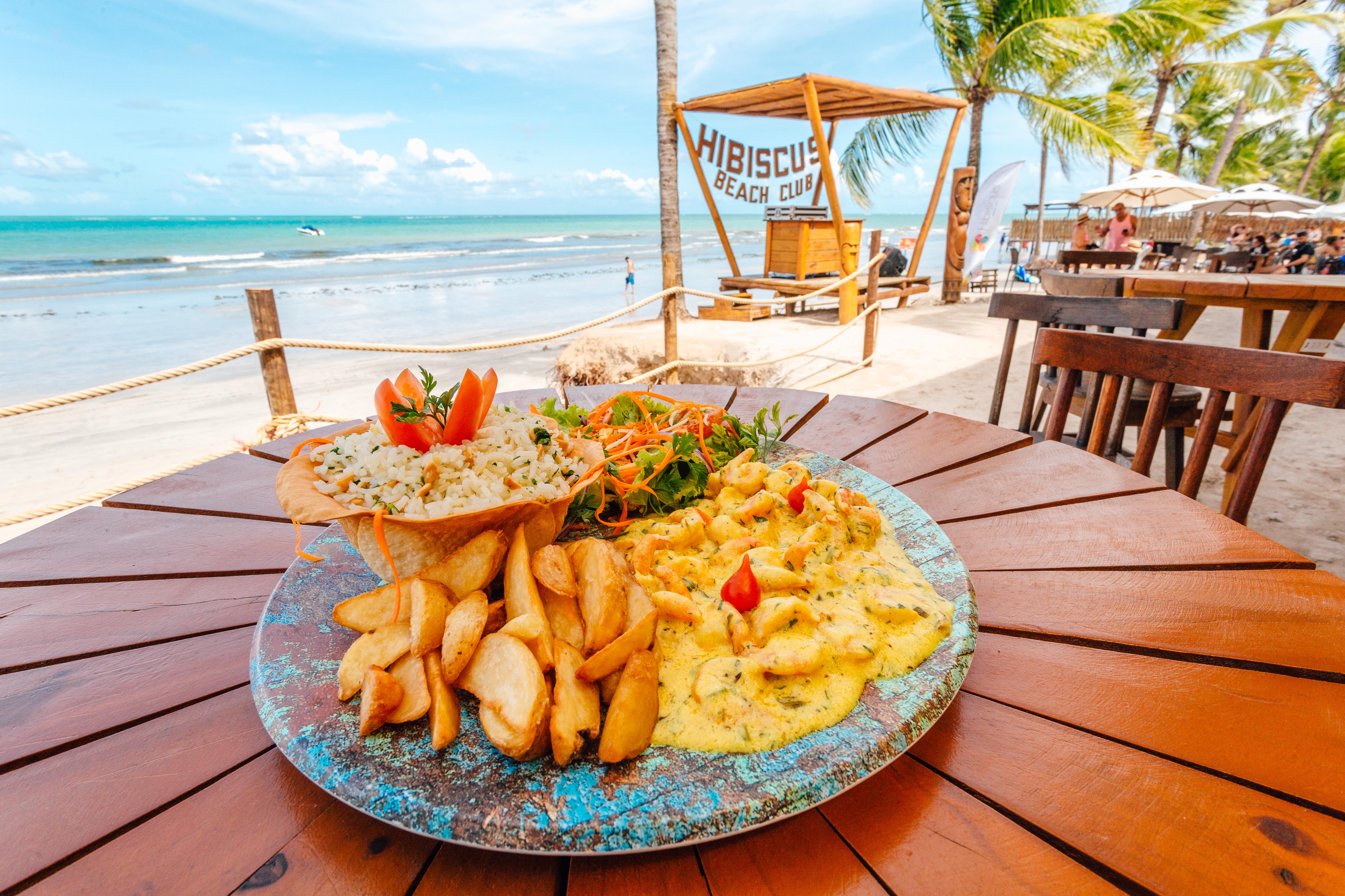 Prato de frutos do mar com o Hibiscus Beach Club e o mar ao fundo