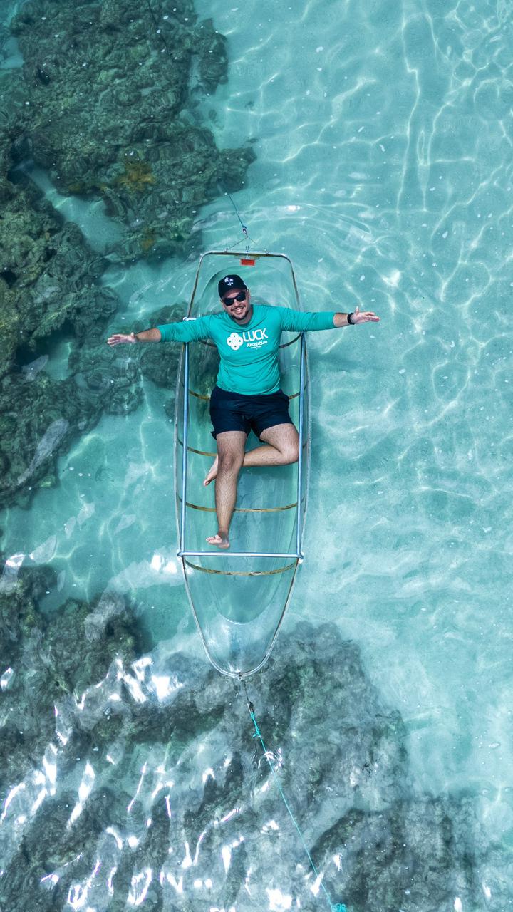 Leo Viana na canoa transparente sobre o mar cristalino de Alagoas