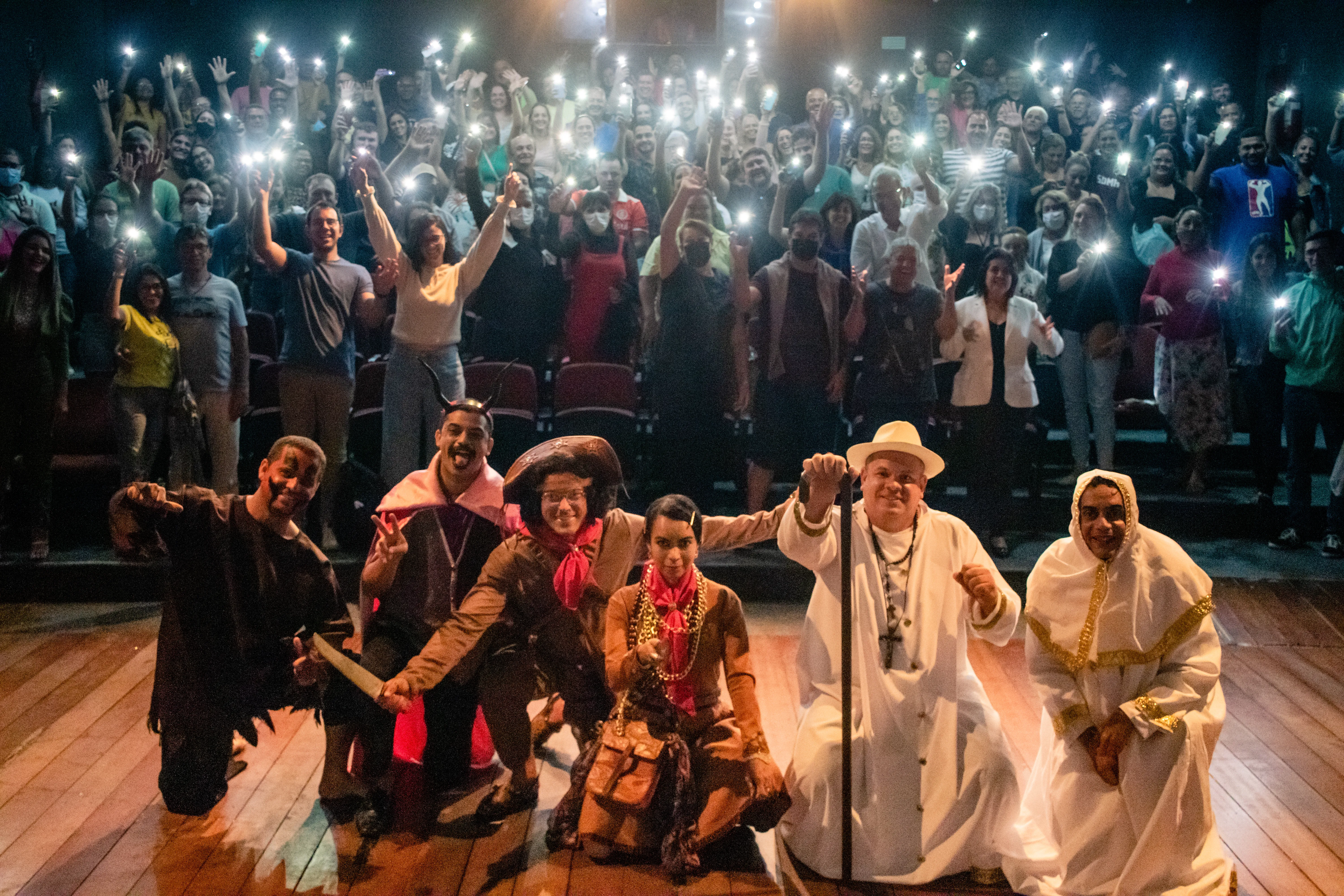Elenco e plateia comemorando ao final do espetáculo O Santo, o Diabo e o Rei do Cangaço